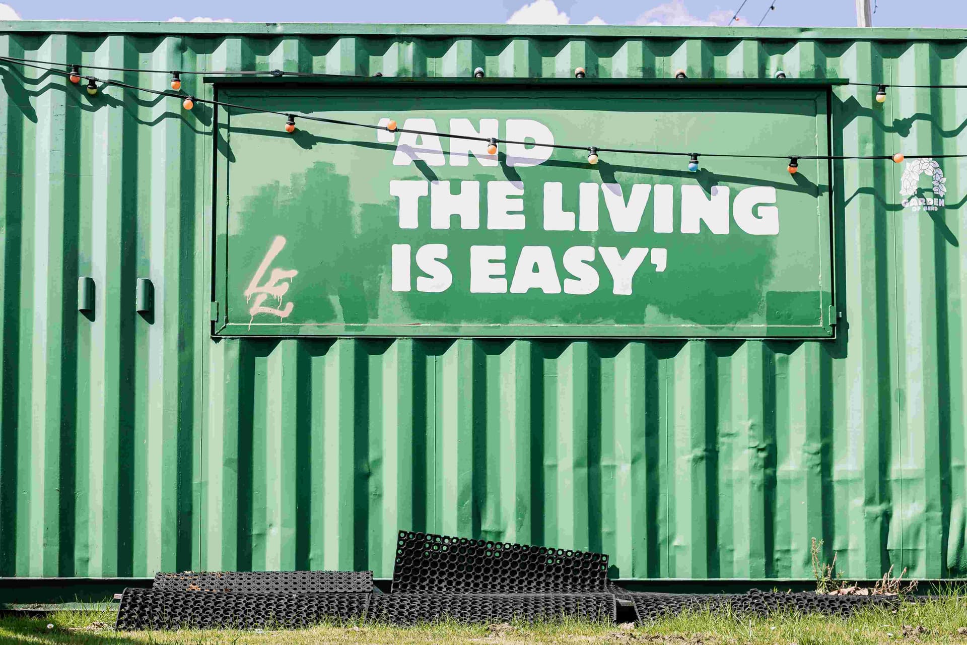 Hier sieht man ein Schild auf einem Container, auf welchem steht: And the living is easy.
